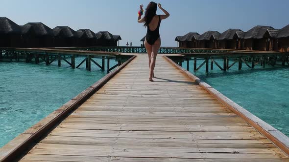 Girl walking on a wood bridge in Maldives