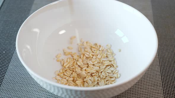 Delicious Porridge Cereals Fall Into White Ceramic Bowl