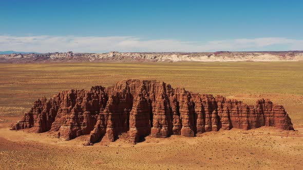 Massive red rock formation towering in the middle of dead wild west desert in Utah, United States of