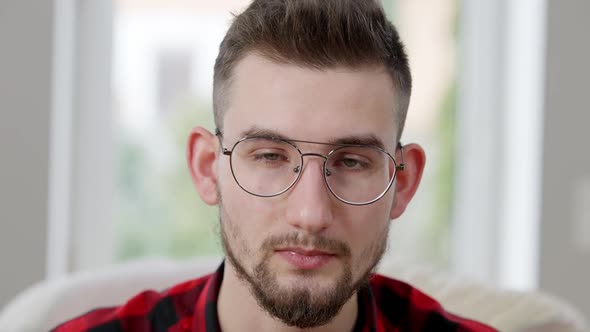 Headshot of Exhausted Caucasian Bearded Man Taking Off Eyeglasses and Rubbing Eyes