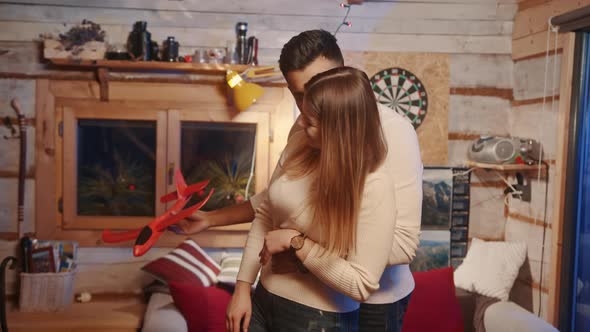 Happy Young Couple Playing with Red Airplane Toy