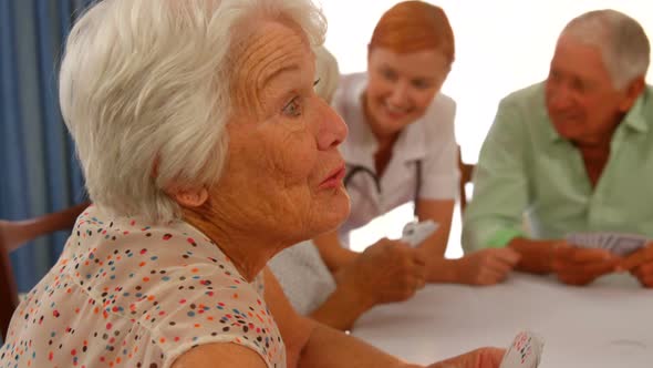 Senior woman talking to senior man while sitting at dinning table