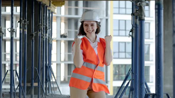 Female architect having fun dancing at construction siteof an under-construction building