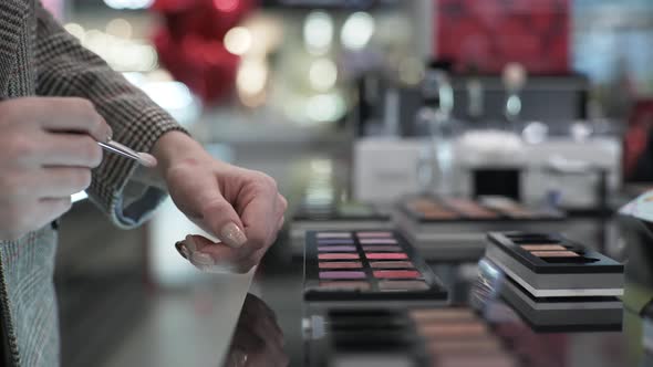 Hands of Buyer Close-up, Female with Brush in Their Hands Are Testing Makeup Cosmetics in Store