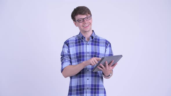 Happy Young Handsome Hipster Man Thinking While Using Digital Tablet