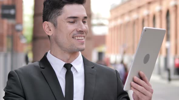 Outdoor Video Chat by  Businessman via Tablet