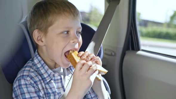 Boy Eating Sandwich in Car