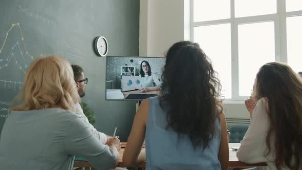 Group of Business People Making Video Call Chatting to Female Colleague and Looking at Display