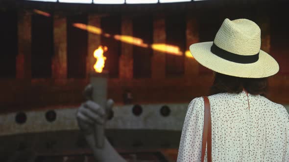 A young girl in a hat looking at the eternal flame in the pantheon