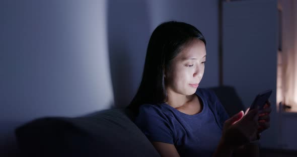 Woman use of cellphone at home in the evening