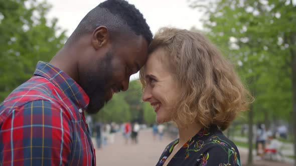 Close Up of Beautiful Young Multiethnic Couple in Love Embracing Spending Time in Summer Park