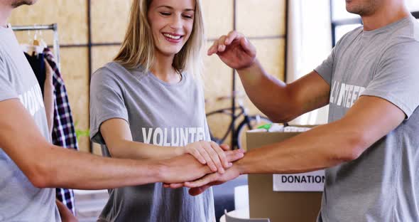 Smiling volunteers with their hands stacked