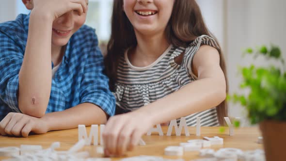 Portrait of Happy Children Playing Board Game with English Letters