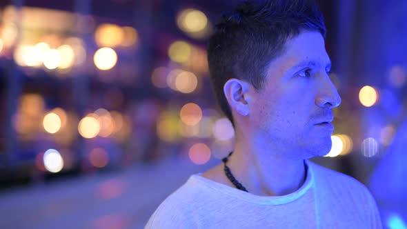 Hispanic Man Thinking Against View of the City at Night