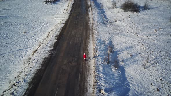 Aerial View of Young Woman Walking on Road in Winter Season