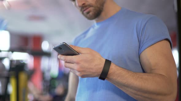 Athlete Launching Application on Smartphone to Synchronize With Fitness Bracelet
