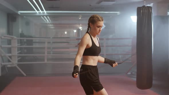 Woman Fighter Trains and Jumping Rope, Coordination Training, Boxing Training in the Gym, Strength