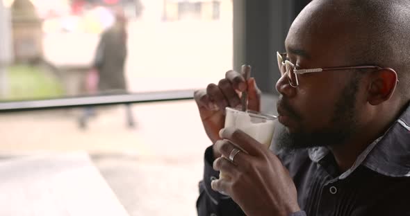 Young Black Businessman Talks on the Phone in a Cafe