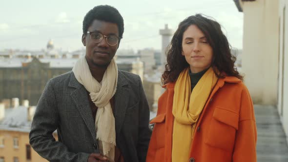 Portrait of Smiling Multiethnic Man and Woman on Rooftop Terrace