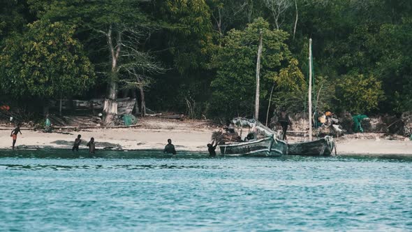 Local African Fishing Village Locals Unload the Dhow Fishing Boat Off the Coast