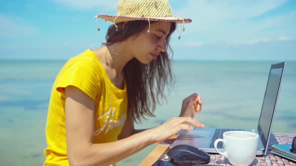 Side View Summer Freelancer Woman Working on Laptop Computer By Blue Sea During Her Travel