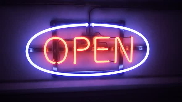 Open neon sign flickering shine in the night. Bar, pub or shop entrance. 4KHD