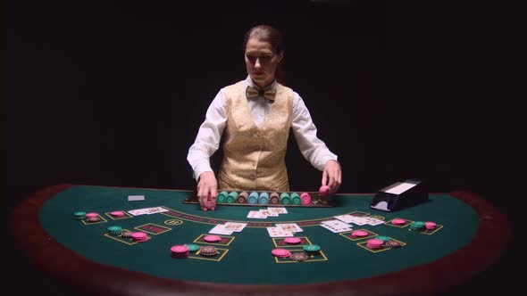 Casino Dealer Autopsy of the Three Cards on the Flop, Playing Poker on the Green Table. Black