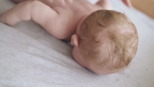 Skilled Pediatrician Massages Actively Newborn Boy
