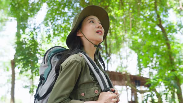 Asian young beautiful woman backpacker traveling alone in forest wild on holiday vacation.