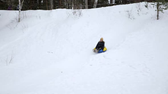 Young Woman Is Sliding From Snow Hill at Tubing in Slow Motion.