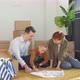 Happy Young Family Looking at Blueprint Planning New Home Interior Design Settling in Homeowners - VideoHive Item for Sale