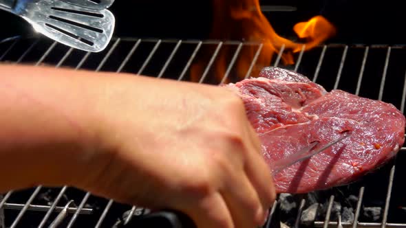 Cook Lays the Steak on the Grill Grate