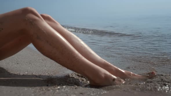 Tanned Woman Legs Smeared Beach Sand on Sunlight Closeup