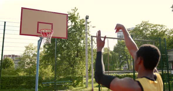 Sporty African American Man Playing with Basketball Ball