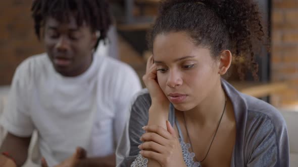 Sad Stressed Young Beautiful Woman Listening to Angry Blurred Man Yelling and Gesturing at