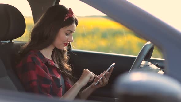 Charming Woman Using Smartphone While Driving Car