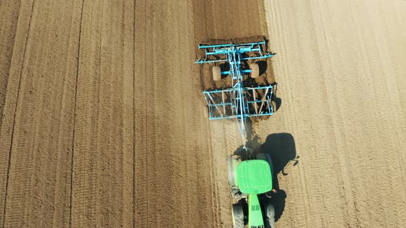 Tractor with Disc Harrows on the Farmland