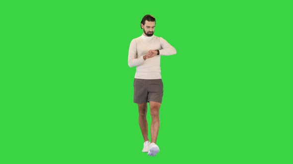 Handsome Sportsman Checking Smart Watch While Walking on a Green Screen Chroma Key