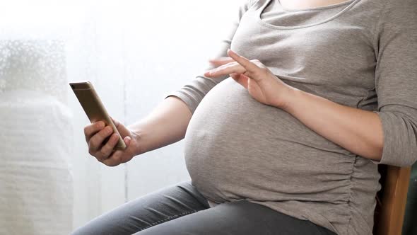 Pregnant Woman Using Smartphone Video Chat