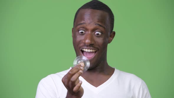 Young Happy African Man Playing with Fidget Spinner