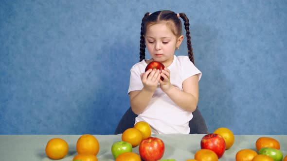 Little Girl Bites Red Apple