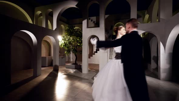 Happy Just Married Couple is Dancing Waltz in Ballroom of Amazing Palace in Night Romantic Dance