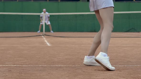 Tennis Club Partners Playing Set, Woman Serving Ball, Back View Slow Motion