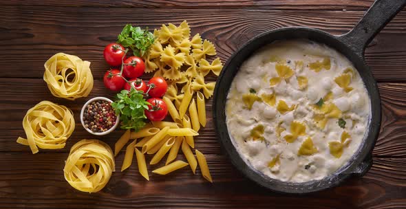  cooking Farfalle Pasta with Creamy Sauce on Iron Cast Pan