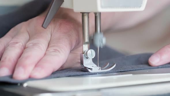 Hands of Seamstress Sewing with a Professional Machine Sewing Workshop