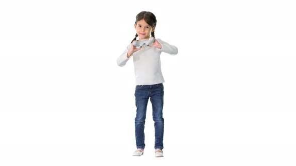 Excited Little Girl Play Videogame Holding Joystick in Her Hands on White Background