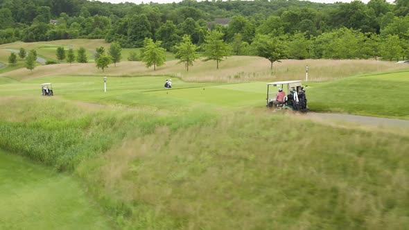 Street level view of golfers and caddies on golf carts