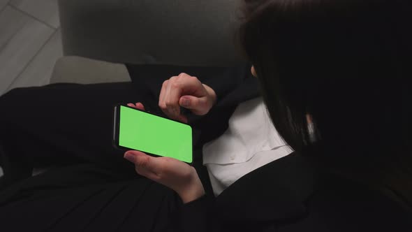 Woman Holding Smartphone Chromakey Green Screen Swiping Scrolling Watching Content at Home or Office