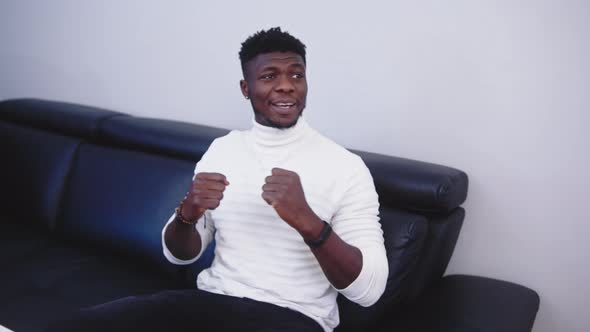 Young Black Man Watching Sport Competition on Tv. Boxing Match