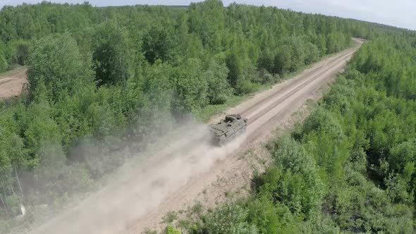 Flying Over the Military Vehicle Driving in Rough Wooded Country